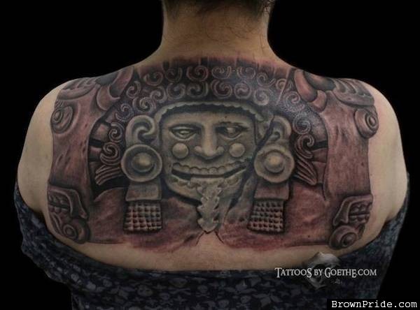 Colored typical looking upper back tattoo of ancient stone statue