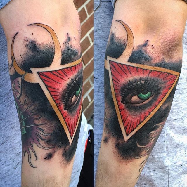 Colorful creepy looking arm tattoo of triangle with woman eye