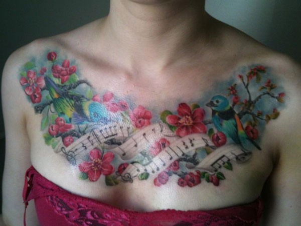 Colorful musical notes and birds on a flowering cherry chest tatoo
