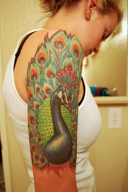 Tatuaje en el brazo, pavo real con la cola pintoresca