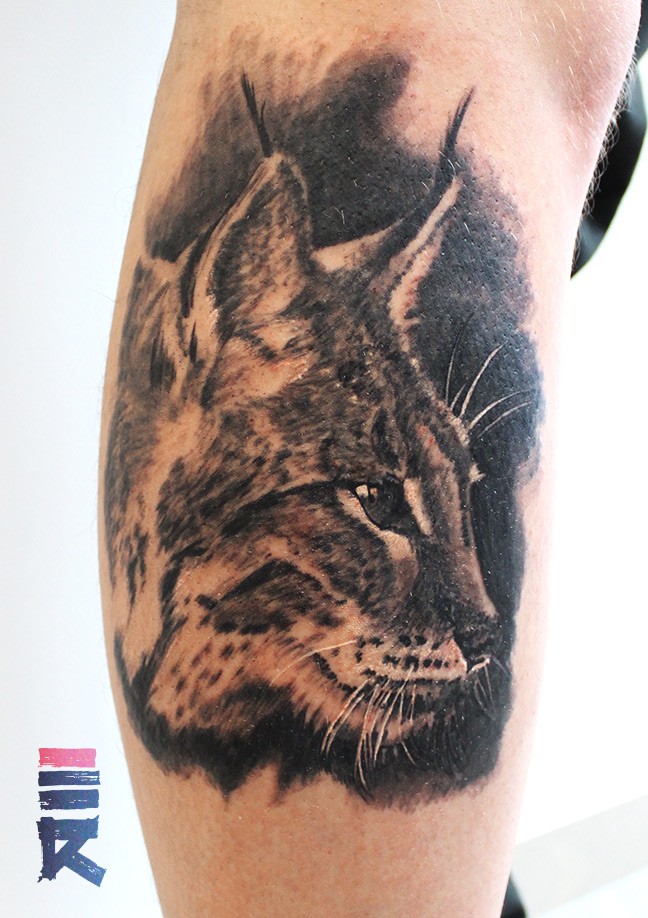 Colorful portrait of lynx tattoo on arm
