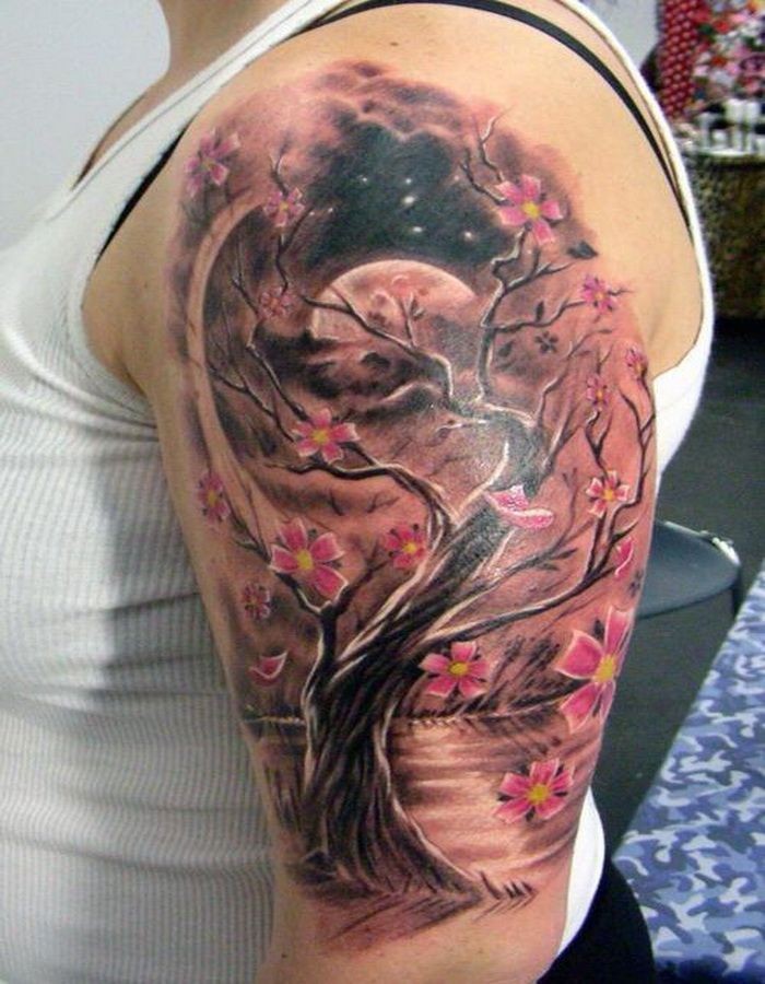 Tatuaje en el brazo, árbol con flores rosas, la noche oscura