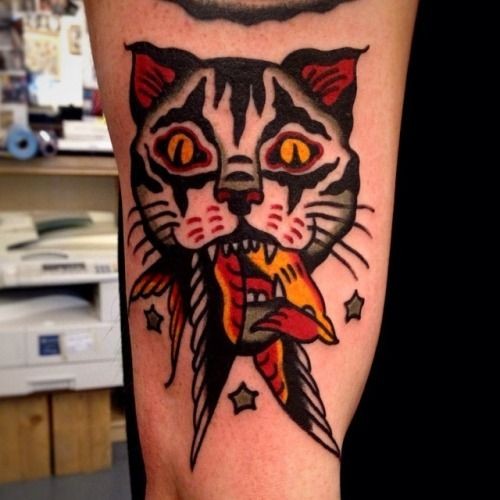 Tatuaje en el brazo, gato con ave en la boca