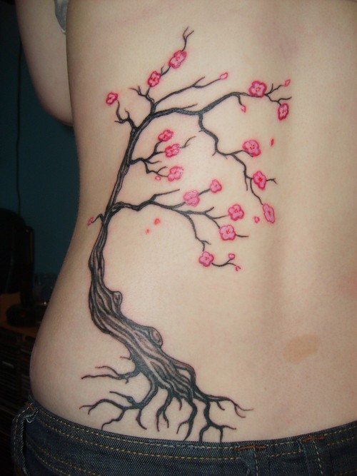 Tatuaggio sulla schiena l&quotalbero con i fiori rosa