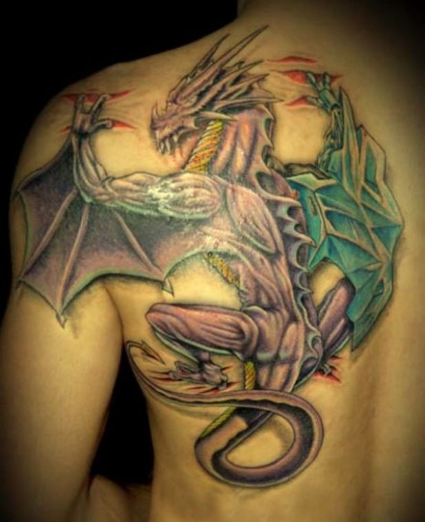 Coloured dragon tearing skin tattoo on shoulder blade