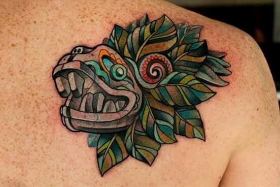 Coloured head of aztec feathered serpent deity tattoo on shoulder blade