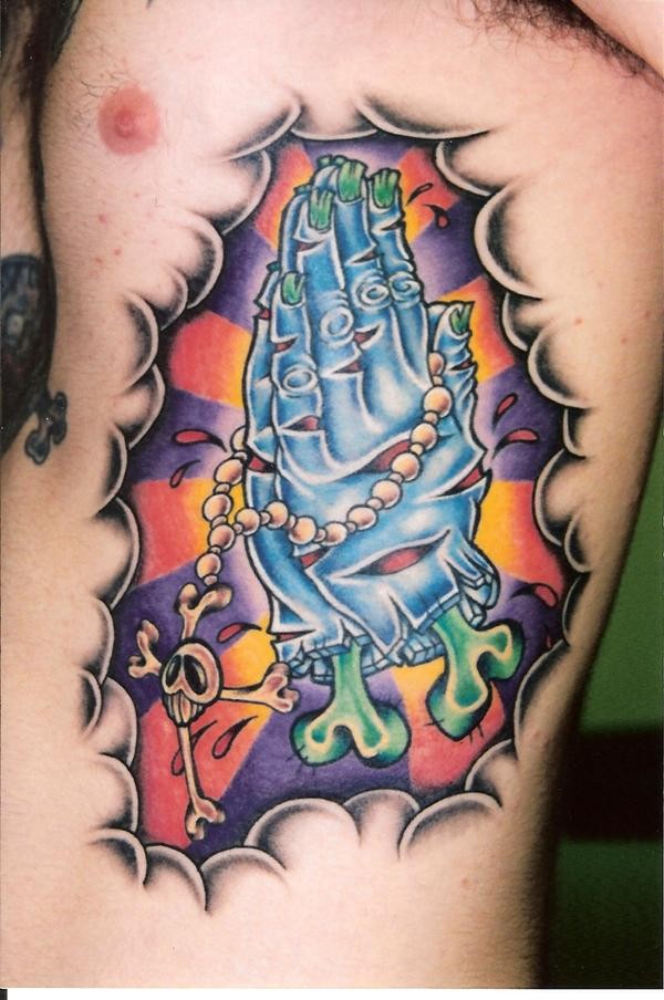 Coloured praying zombie hands tattoo on ribs