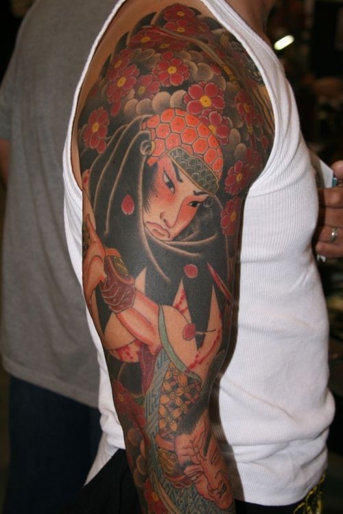 Tatuaje en el brazo, samurái entre flores rojos