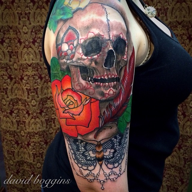 Tatuaje en el brazo, cráneo de perfil, rosa, mariposa