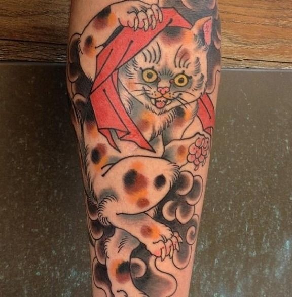 Coloured spotted playing cat tattoo
