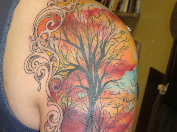 Tatuaje en mitad de la manga de un árbol coloreado.