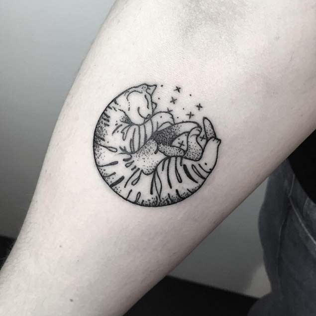 Comforting sleeping cat black and white circle shaped forearm tattoo