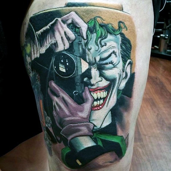 Comic books style colored thigh tattoo of smiling Joker with camera