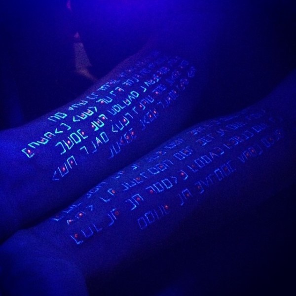 Tatuajes en los antebrazos, inscripción larga de tinta ultravioleta
