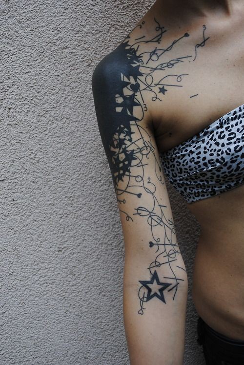 Tatuaje en el brazo, mancha grande con estrellas y corazones diminutas, tinta negra