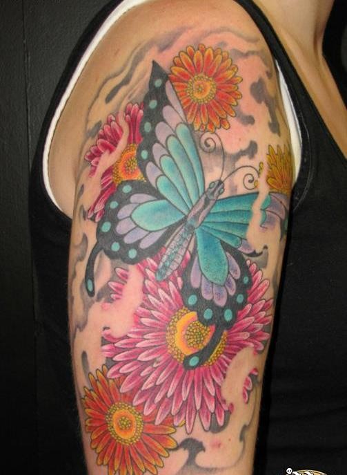 Tatuaje en el brazo, mariposa grande preciosa entre flores bonitas
