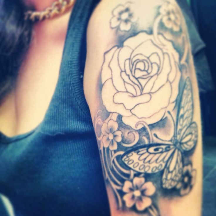 Tatuaje en el brazo, flor no pintada y mariposa