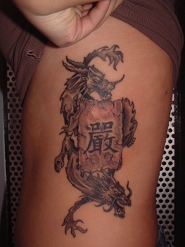 Tatuaje en el costado,
 dragones y rollo con jeroglíficos