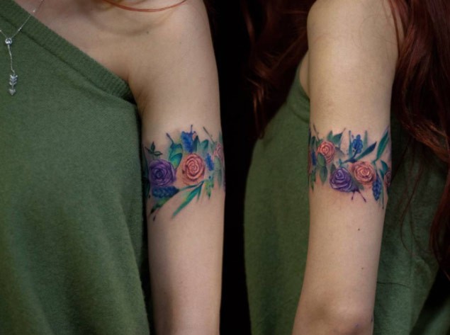 Cool colored arm band shaped tattoo of flowers