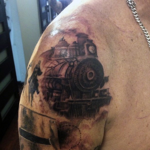 Cool colored big old train with cowboys tattoo on upper arm