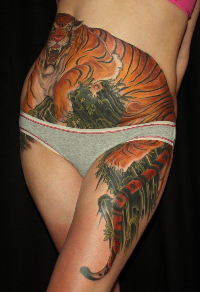 tigre minaccioso in cespuglio fresco colorato tatuaggio sulla pancia