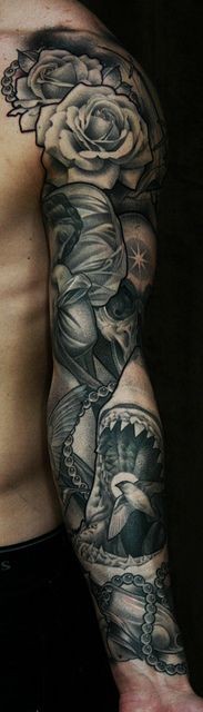 Tatuaje en el brazo, flores con cráneo y tiburón, diseño monocromo