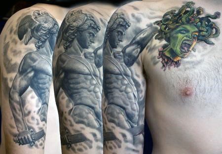 Tatuaje en el brazo y hombro, estatua antigua de guerrero con espada con cabeza de  Medusa