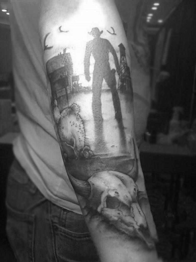 Cool designed western themed black and white cowboy and city tattoo on sleeve
