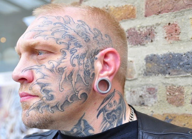 Cooles Tattoo für Männer auf dem Gesicht