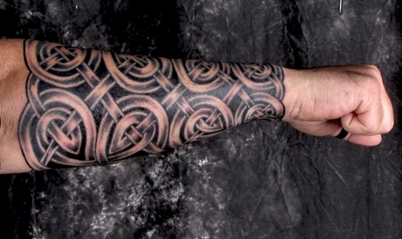 Cool gray-ink celtic body armor tattoo sleeve on forearm