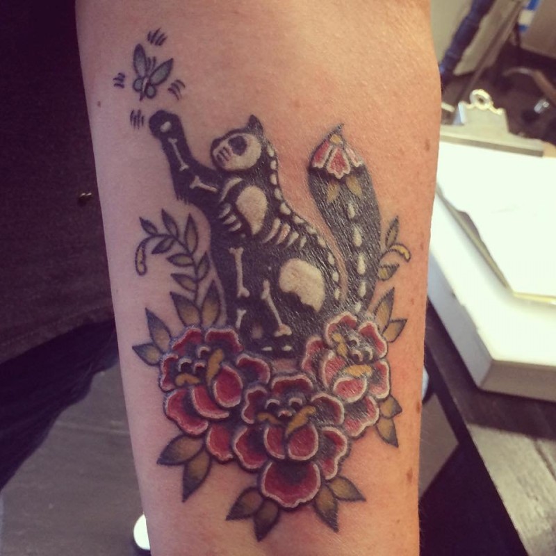 Cool illustrative style arm tattoo of cat with skeleton and flowers