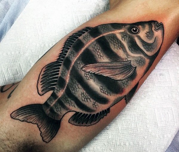 Cool natural looking detailed and colored fish tattoo on arm