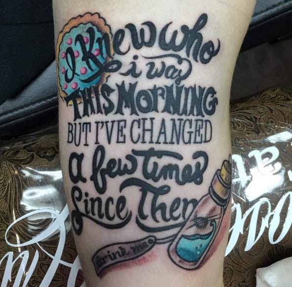 Cool pained big black ink lettering tattoo on arm with little magic bottle