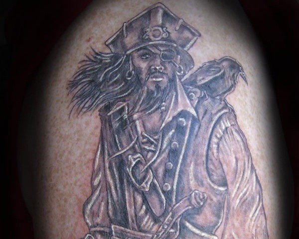 Tatuaje negro blanco  de pirata severo con loro en el hombro