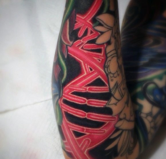 Cool red colored little DNA tattoo on arm