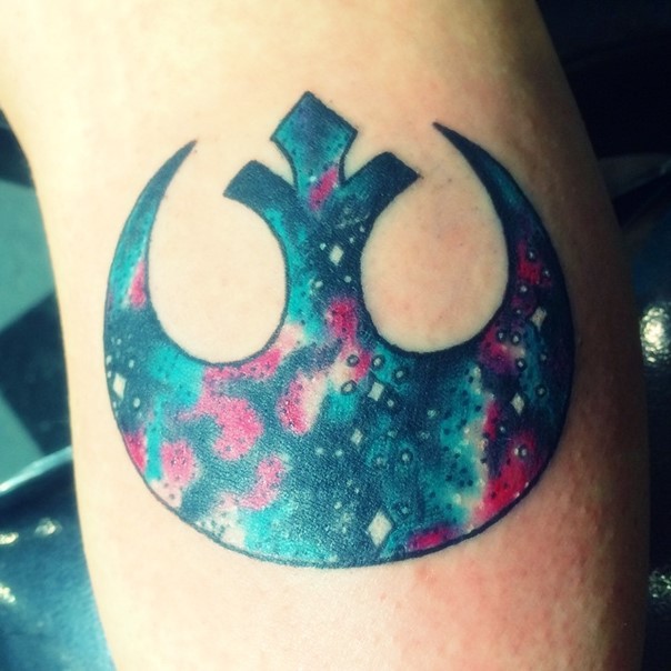 Cool space themed colorful Rebel Alliance emblem tattoo on forearm