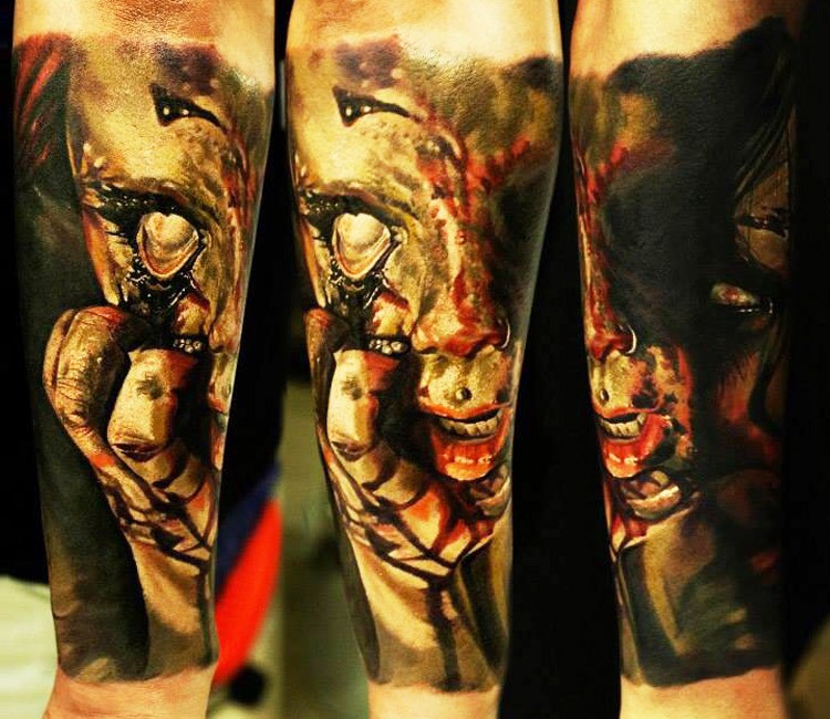 Creepy colored horror style forearm tattoo of demonic woman face