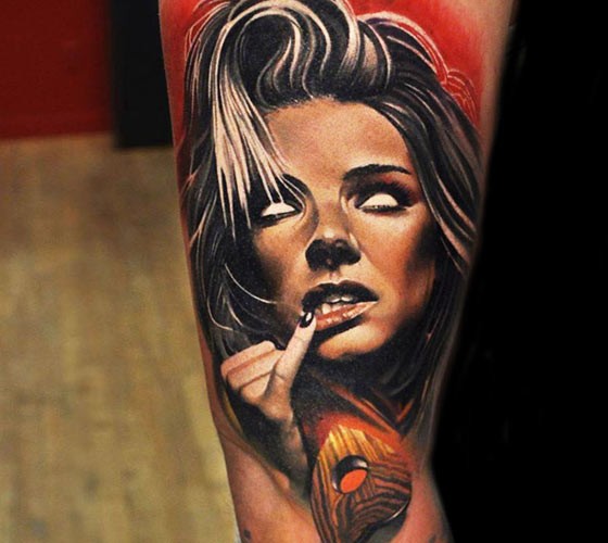 Creepy looking colored arm tattoo of demonic woman face