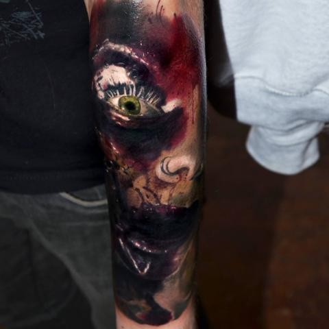 Creepy looking colored arm tattoo of bloody monster face