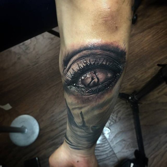 Creepy looking colored arm tattoo of human eye with hands