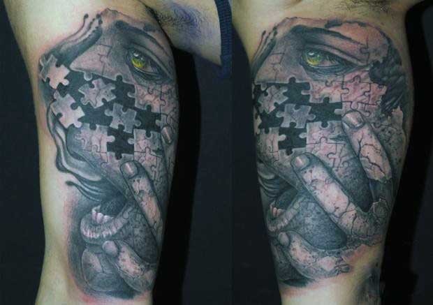 Creepy looking colored biceps tattoo of puzzle picture stylized with scared woman face