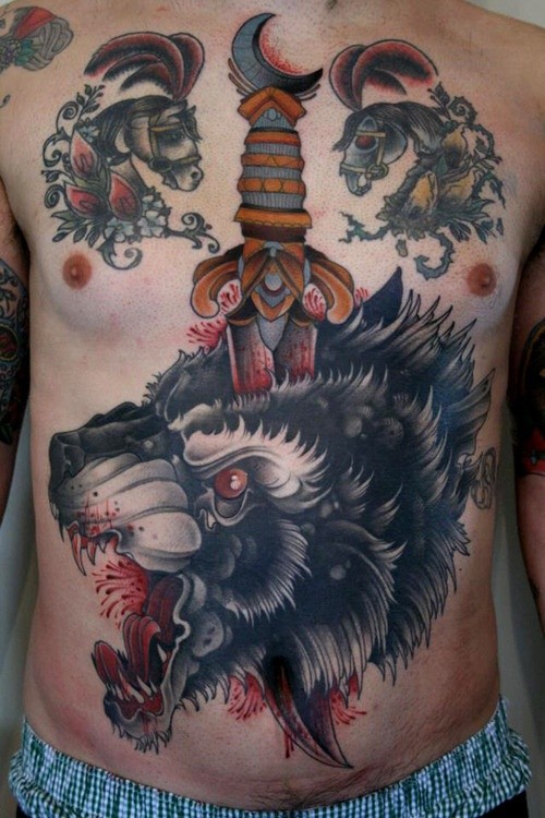 Creepy looking colored chest and belly tattoo of wolf with bloody dagger