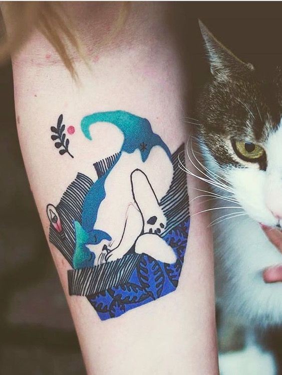 Creepy looking colored forearm tattoo of sleeping cat by Joanna Swirska