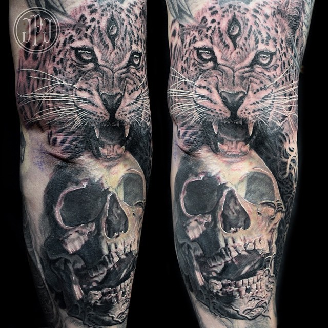 Creepy looking detailed arm tattoo of leopard with three eyes and human skull