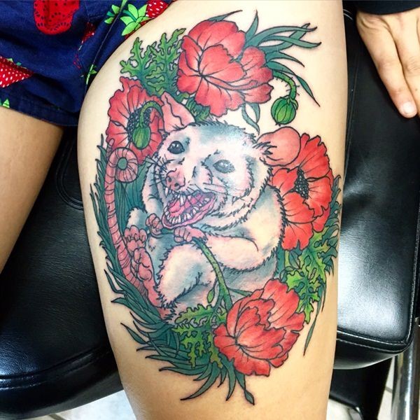 Creepy monster like white mouse in red poppy flowers detailed thigh tattoo