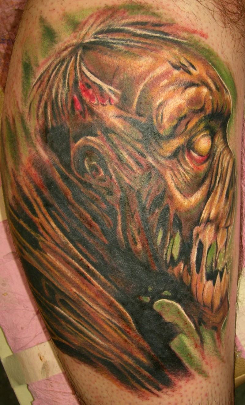 Creepy painted and colored big monster face tattoo on arm
