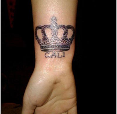 Tatuaje en la muñeca, corona grande con nombre