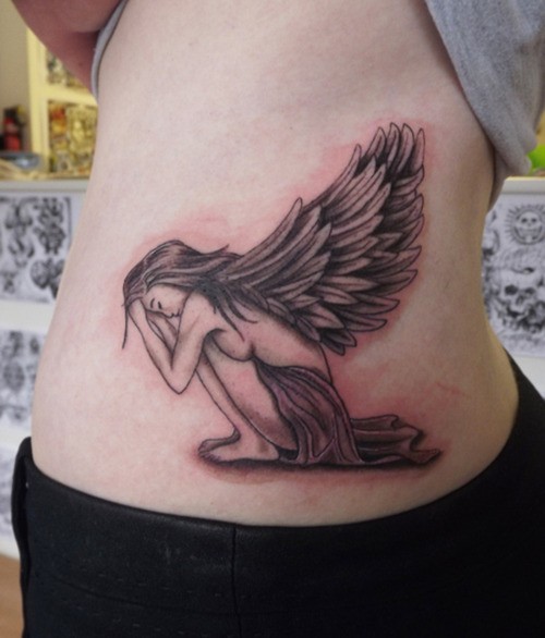 bel angelo ragazza piangendo seduta piegata tatuaggio su costolette