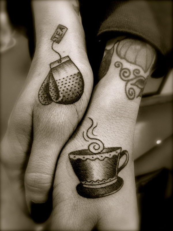 Tatuajes en las manos, 
taza de té y bolsita de té