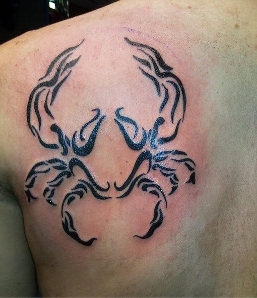 Curl crab tattoo on man&quots shoulder blade